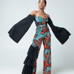 A Patterned Ankara Jumpsuit with Pleats on the right, Feathers around Cleavage, Corset style middle, Wide Mouthed - Pleated Off shoulder sleeves.