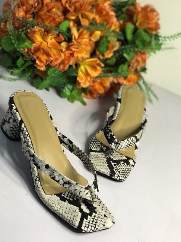 Chic white and black leopard print slippers heels by Nigerian designer. Unleash your style with this bold footwear.