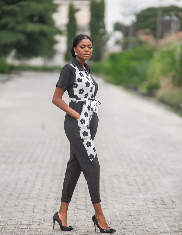Black jumpsuit with stylish black and white floral patterns, complete with a waist-cinching attached belt. Perfect for a Chic and Comfortable Look.